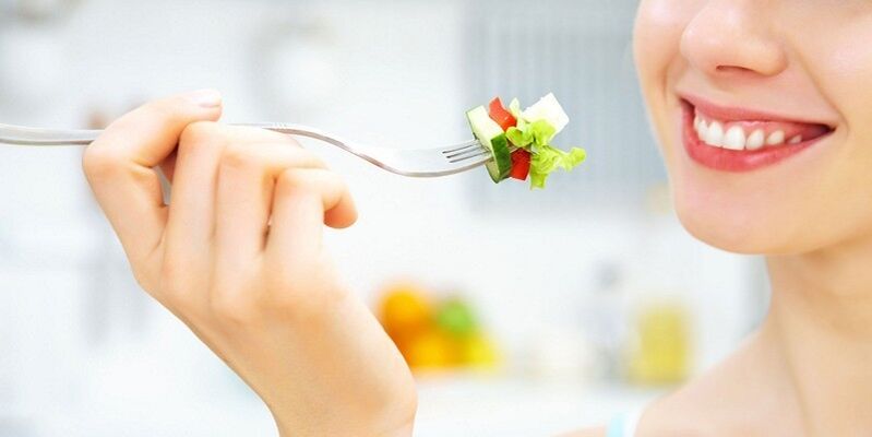 Garota comendo salada de legumes, perdendo peso com sua dieta favorita